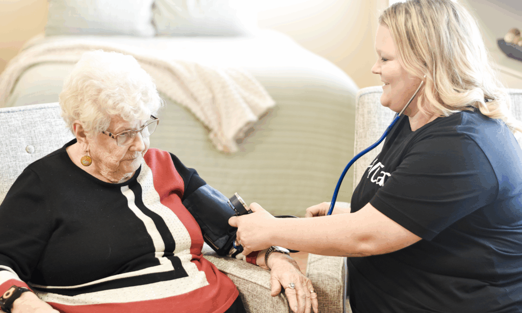 Female seated wearing a blood pressure cuff next to nurse wearing a stethoscope